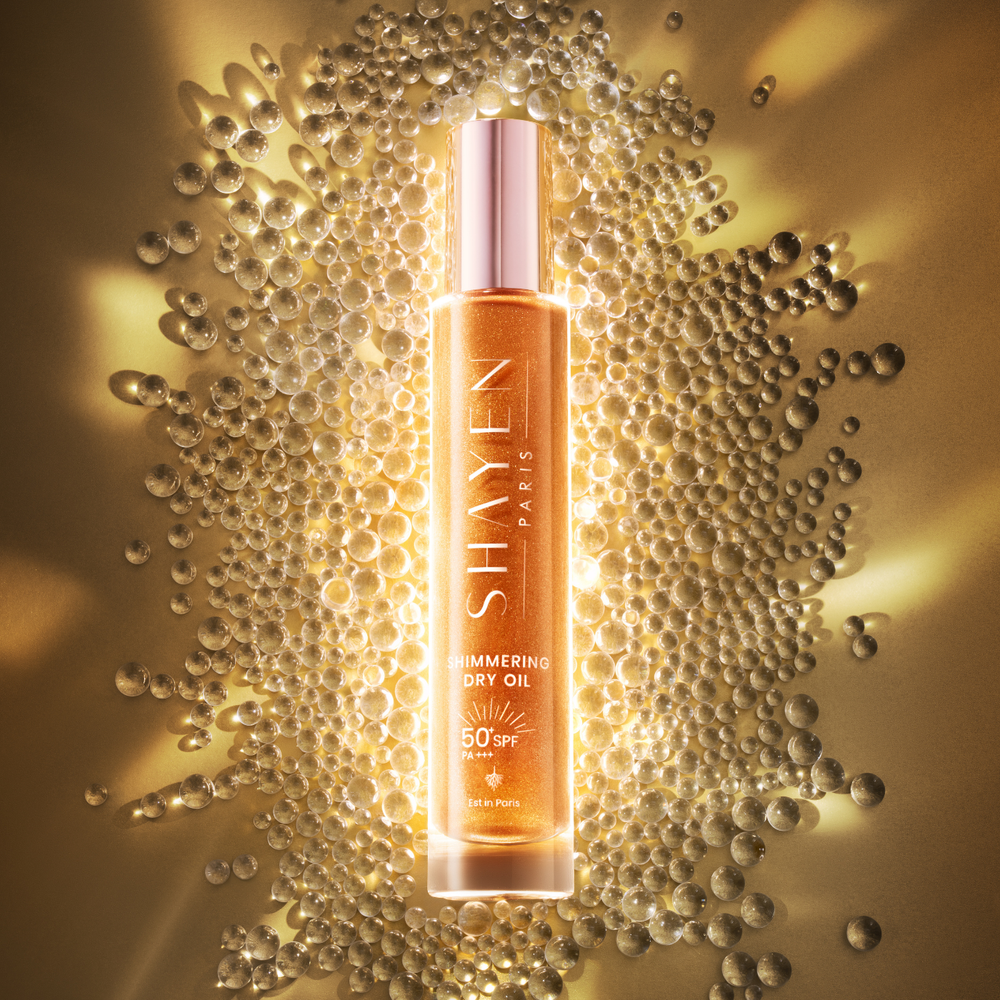 Shayen Paris shimmering dry oil bottle surrounded by bubbles on a gold background
